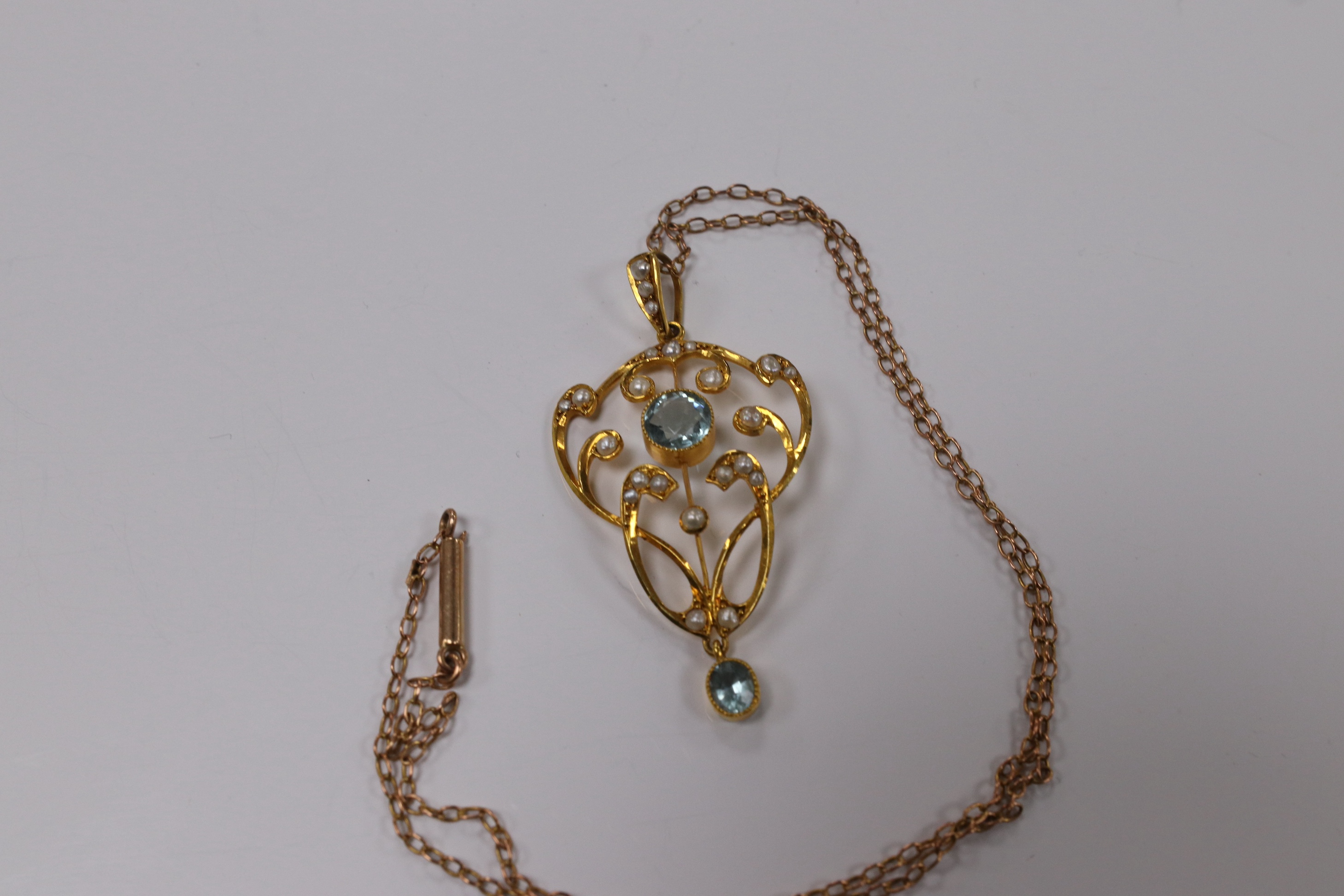 An Edwardian 9ct and gem set drop pendant, 45mm, on a yellow metal fine link chain, 36cm, gross weight 4.2 grams. Condition - good